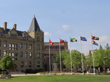 A building at University of Winnipeg with the flags of several Indigenous Nations flying outside it