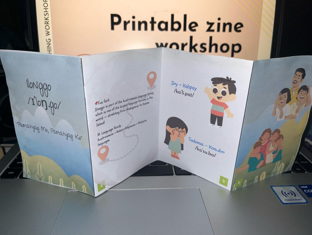 Zine printed and folded on a laptop displaying the Language Lodge workshop