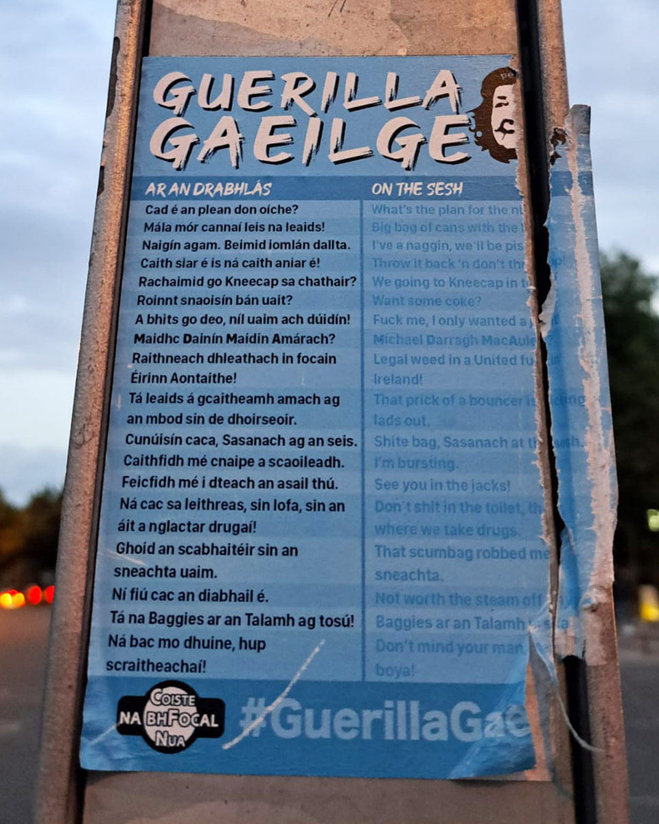 A sticker on a street sign reading "Guerilla Gaeilge" and a list of Irish vocabulary